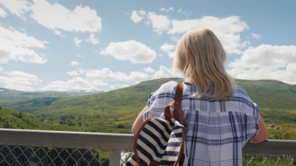 Osoba s batohem se dívá na majestátní vodopád Woringsfossen v Norsku. Působivá krása skandinávské přírody — Stock video