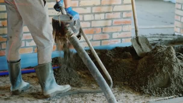 Der Bauherr setzt einen halbtrockenen Mörtel für die Veredelung des Bodens ein — Stockvideo