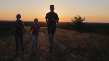 İki çocuklu bir kadın doğada koşar, aile sporu kavramı.