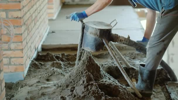 Der Bauherr setzt einen halbtrockenen Mörtel für die Veredelung des Bodens ein — Stockvideo