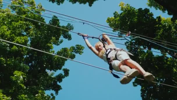 A brave child takes steps on a staggered cable at a height. Overcome fear concept — Stock Video