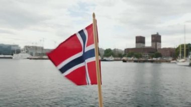 Norveç bayrağıyla Oslo şehir sınırının arka planında yürümek