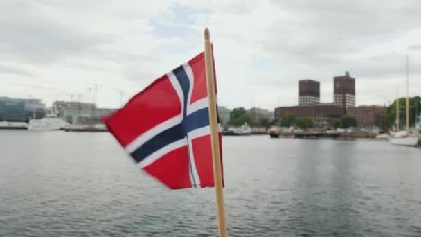 Caminando con la bandera de Noruega en el fondo de la línea de la ciudad de Oslo — Vídeos de Stock