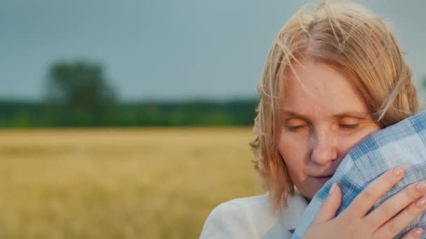 Una mujer se acurruca hasta el hombro de un hombre, un fuerte viento golpea su cabello — Vídeos de Stock