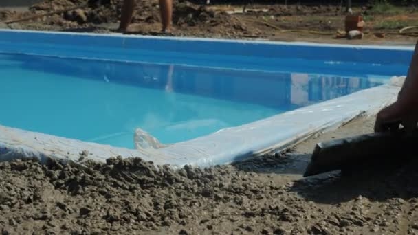 Будівельники наливають бетон навколо басейну, роблять мощення . — стокове відео