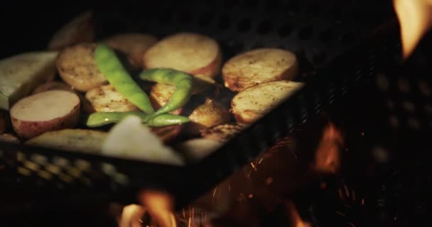 アスパラの入ったジャガイモは、開いている火の上にフライパンで揚げられます。おいしいピクニックフード — ストック動画