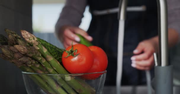 Eine Frau wäscht Tomaten, im Vordergrund eine Schüssel Spargel — Stockvideo