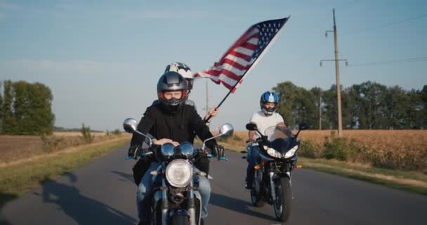 Молодежь путешествует на мотоциклах с флагом США — стоковое видео