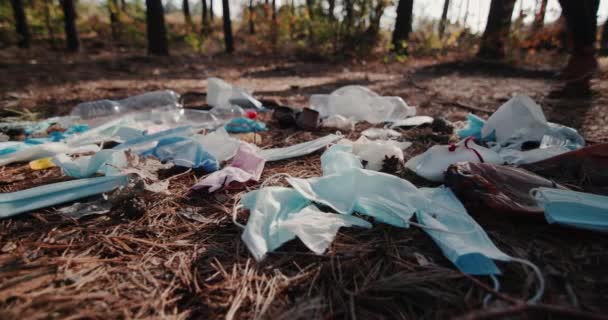 Ein Mann geht durch den Wald an einer Mülldeponie aus Hausmüll vorbei — Stockvideo