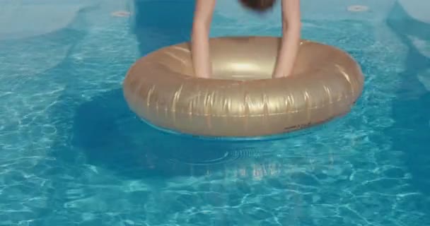 Το παιδί βουτάει στην πισίνα, πηδά στα νερά και στο κέντρο του φουσκωτού κύκλου. Καλοκαιρινή διασκέδαση σε ζεστό καιρό — Αρχείο Βίντεο