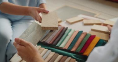 Tasarım ekibi projeleri için tamamlayıcı malzemeler seçiyor, kumaş, ahşap ve duvar kağıdı örneklerini karşılaştırıyor