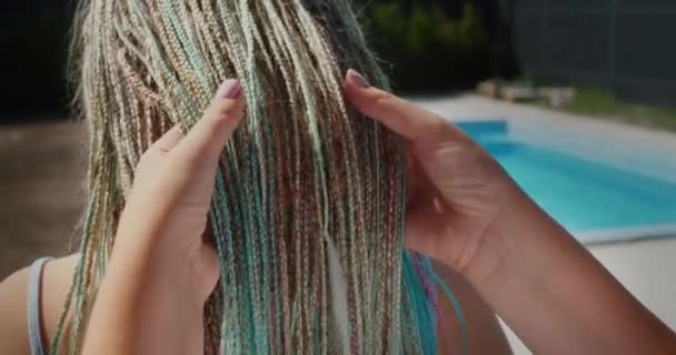 A woman admires her daughters Afro-braids, holds them in her hand. Stand by the pool — Stock Video