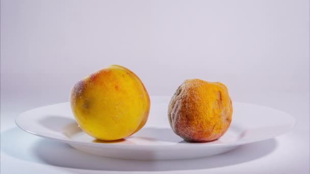 Juice och vitalitet flödar från en persika till en annan. Begreppet donation, vård och föryngring. Lång tid förfaller — Stockvideo