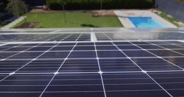 Paneles solares en el techo de la casa, debajo se puede ver la piscina y el césped verde. — Vídeos de Stock