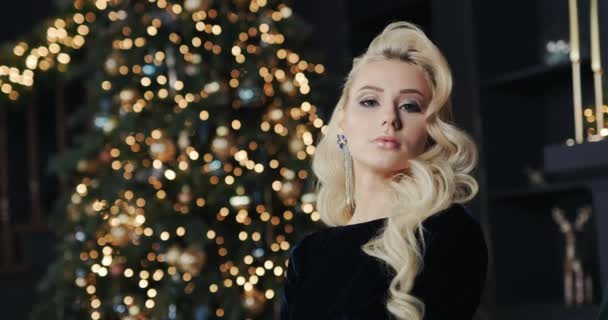 Atractiva joven sobre fondo de luces borrosas del árbol de Navidad — Vídeo de stock