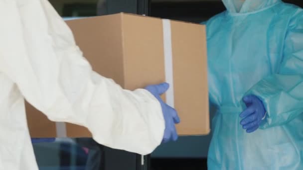 Menschen in Schutzanzügen laden Kisten mit Medikamenten ab — Stockvideo