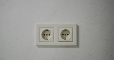 Evin duvarında çift Avrupalı elektrik prizi var. Kamera bir prizle duvara doğru yavaşça hareket ediyor.