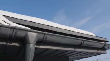 Kanalizasyon sistemi olan bir çatı. Güneşin altında kar erir.