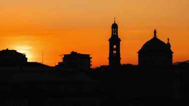 İtalya 'nın Bergamo şehrinin siluetinde, Santa Maria Immacolata delle Grazie' nin kubbesi ve çan kulesinin gölgesinde altın gece ışığında güneşin batışının zamanı. Yüksek kalite 4k görüntü
