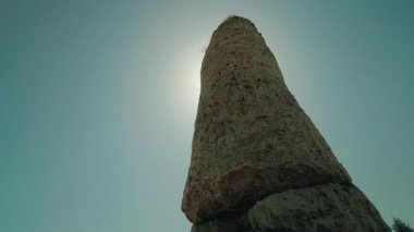 Bulgaristan 'ın Pobiti Kamani kentindeki uzun kireçtaşı sütunu, güneş ışığındaki eşsiz doğal kaya oluşumunu vurgulayarak, parlak yaz gökyüzüne karşı alçak bir açıdan çekildi. Yüksek kalite 4k görüntü