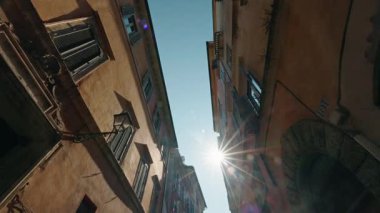 Roma 'nın dar sokak manzaralı pencereleri kepenkli yüksek tarihi binalar arasında gün ışığı parlıyor. 