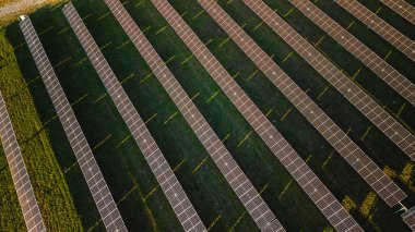 Top view of large solar power plant with rows of photovoltaic panels generating renewable electricity under sunlight 