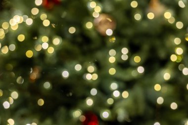 Parlak bokeh ışıklarıyla Noel ağacının yakın görüntüsü, sıcak tatil aydınlatmasına yumuşak bir odak, neşeli bir atmosfer yaratıyor. Yüksek kalite fotoğraf