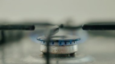 Gaz alevini yakmak ve sabah kahvesini demlemek için ocağın üzerine kahve demlemek, sıcaklığı ve sıcaklığı sembolize eden ev mutfağı sahnesi. Yüksek kalite 4k görüntü