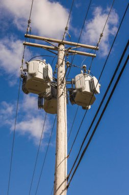 Birleşik Devletler 'de mavi gökyüzünün altında çoklu trafolar ve elektrik hatları olan elektrik direği. Yüksek kalite fotoğraf