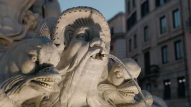 Roma 'da, mitolojik figürler ve aydınlanmış heykeller üzerinde su yansımaları olan bir mermer çeşmenin akşam görüntüsü. Yüksek kalite 4k görüntü