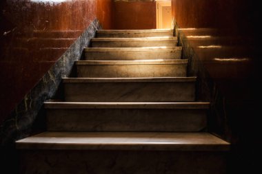 Eski Roma evindeki eski mermer merdiven sıcak güneş ışığıyla cilalı duvarlara dramatik gölgeler bırakıyor. Yüksek kalite fotoğraf