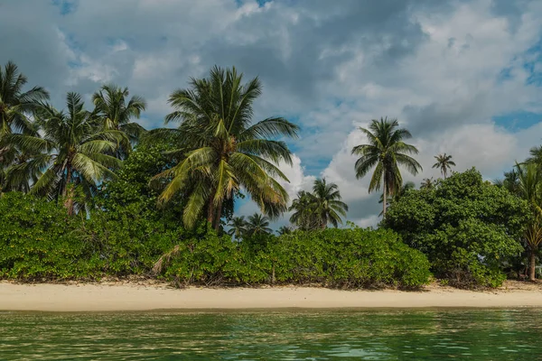Samui Adası 'ndaki Lipa Noi' de palmiye ağaçları ve kumlu plajlı tropik sahil şeridi sakin deniz suyu ve bulutlu mavi gökyüzü altında yemyeşil. Yüksek kalite fotoğraf