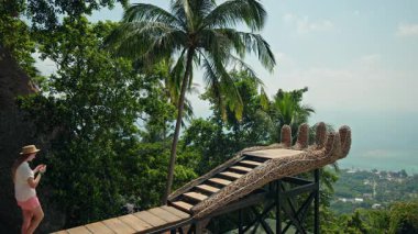 Genç kız el şeklindeki bakış açısına doğru yürüyor ve Koh Samui 'de akıllı telefondan tropikal manzarayı çekiyor. Yüksek kalite 4k görüntü