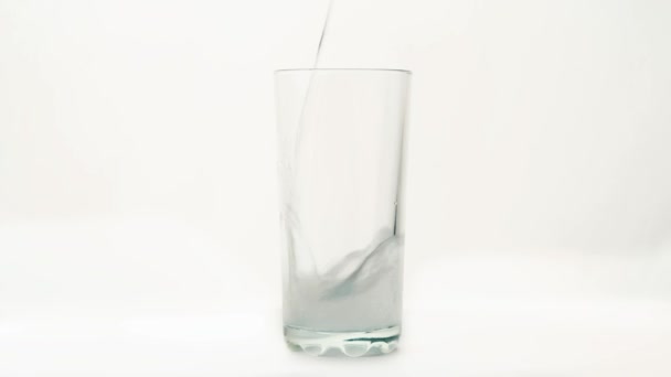 Verser de l'eau sur du verre sur fond blanc 