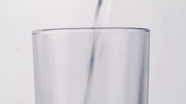 Verser de l'eau sur du verre sur fond blanc — Video