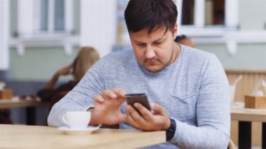 Dostum gülümseyerek telefonu, akıllı telefon, Cafe, gadget ile çalışır