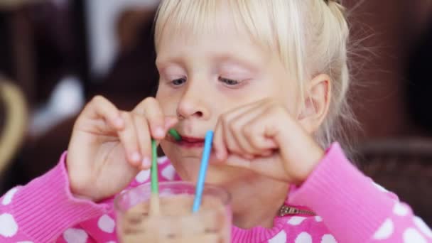 Blond child eating ice cream in cafe, smiling — Stock Video