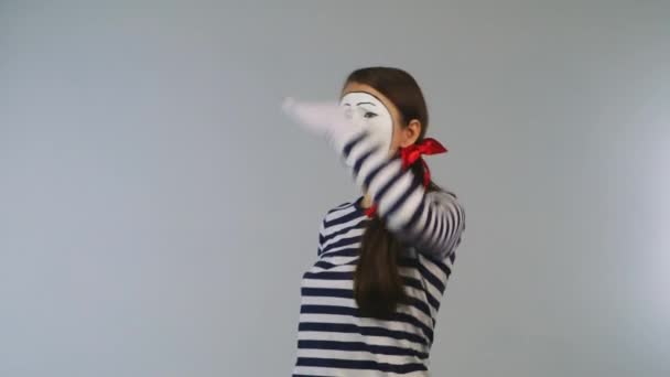 Веселая девушка смотрит через бинокль на белом фоне — стоковое видео