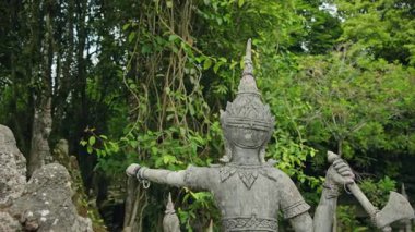Samui 'deki Sihirli Bahçe' de, yoğun tropikal ormanlarla çevrili taş heykel ve barışçıl bir kültür ortamında asılı sarmaşıklar. Yüksek kalite 4k görüntü