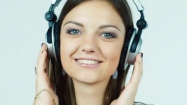 Kulaklıklar müzik dinlemek ve gülümseyen çekici esmer kadın