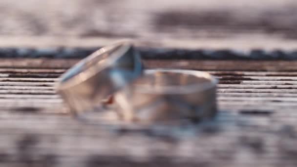 Anillos de boda sobre un fondo de madera — Vídeo de stock