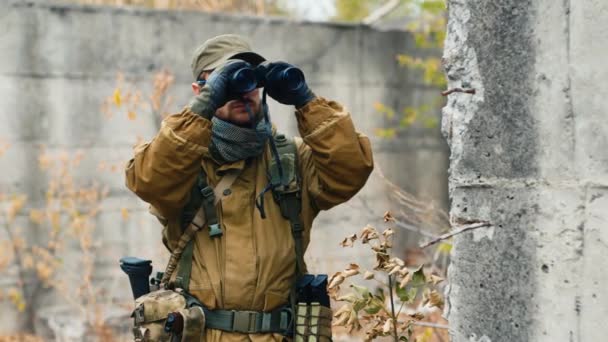 Homem em camuflagem olhando através de binóculos — Vídeo de Stock