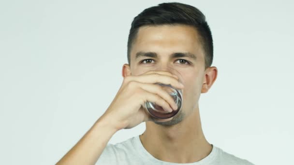 Le jeune homme boit de l'eau dans un verre — Video