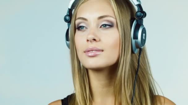 Привлекательная блондинка, слушающая музыку и мечтающая, улыбающаяся — стоковое видео