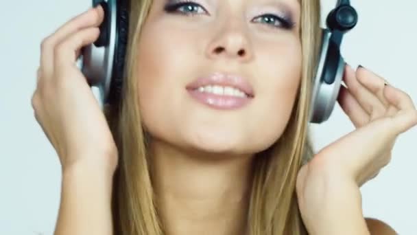 Chica rubia escuchando música en los auriculares y bailando intensamente — Vídeos de Stock