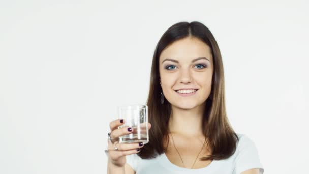 Attractive brunette drinking water on a white background — Stock Video