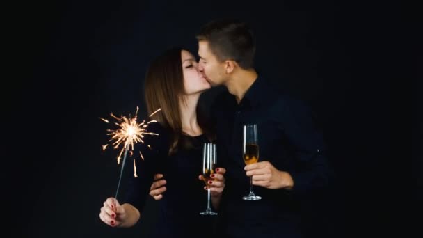 Casal jovem com copos de champanhe e um sparkler — Vídeo de Stock