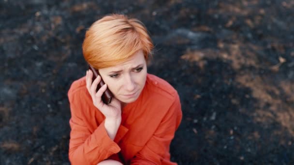 The sad woman sitting on the ground with the phone — Stock Video