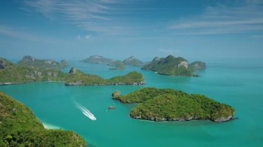 Zümrüt lagünün yemyeşil kireçtaşı adalarla çevrili havadan görünüşü Tayland 'daki Ang Tanga Denizcilik Parkı' ndaki sakin tropikal suları geçen sürat teknesi. Yüksek kalite 4k görüntü