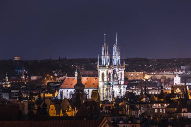 Prag Eski Kasabası 'nın akşam manzarası. Çek Cumhuriyeti' nin tarihi çatılarında Tyn 'dan önce Meryem Ana Kilisesi' nin parıldayan gotik kuleleri.